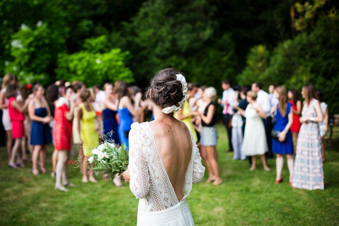 bride looking back at her wedding guests holding a natural white bouquet